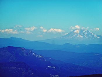 Scenic view of mountains against blue sky