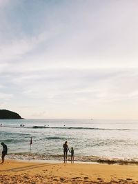 People on beach against sky