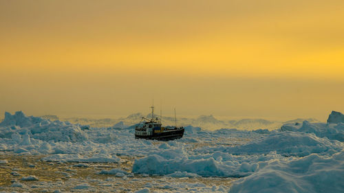 Boat sailing on sea against sky during sunset