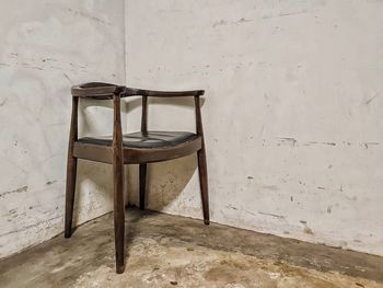 Empty chair on table against wall