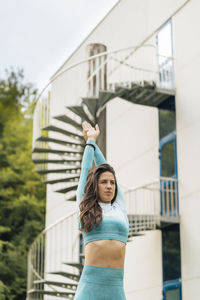 Portrait of woman standing against building