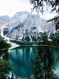 Scenic view of lake by snowcapped mountains against sky