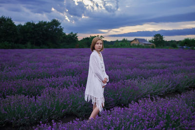 Portrait of cute girl standing on lavender field