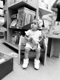 Full length of boy sitting on shelf