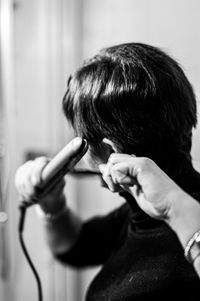 Close-up of woman straightening hair