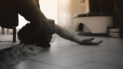 Low section of woman on tiled floor at home