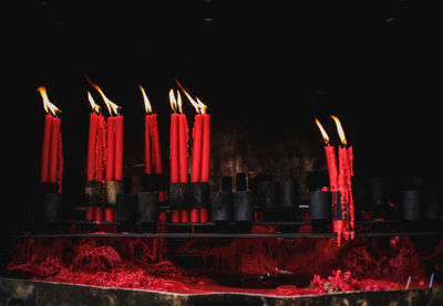 Close-up of lit candles against black background