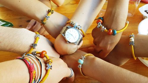 Cropped hands of friends wearing bracelets