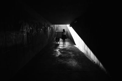 Rear view of man walking in tunnel