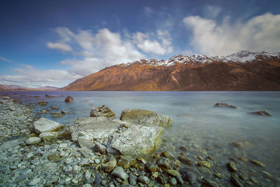 Scenic view of sea and mountains against sky