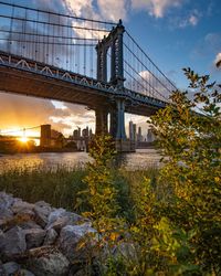 Bridge over river against cloudy sky