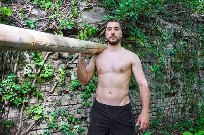 Portrait of young man carrying wood