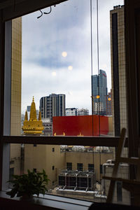 Buildings in city against cloudy sky
