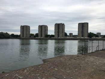 View of cityscape by sea against sky