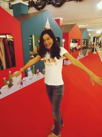 Portrait of smiling young woman standing on red floor