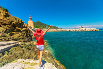 Full length of man standing by sea against blue sky