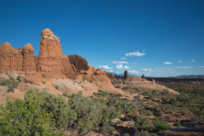 Rock formations on landscape against blue sky