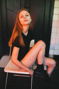 Woman sits on a chair illuminated with red light