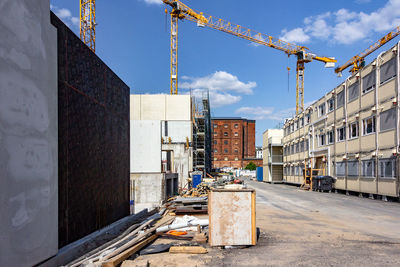 Construction site by buildings in city against sky