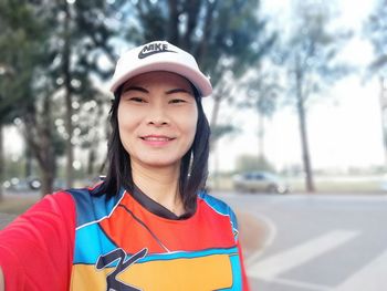 Portrait of smiling woman standing on road 