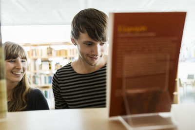 Young students selecting books in college library