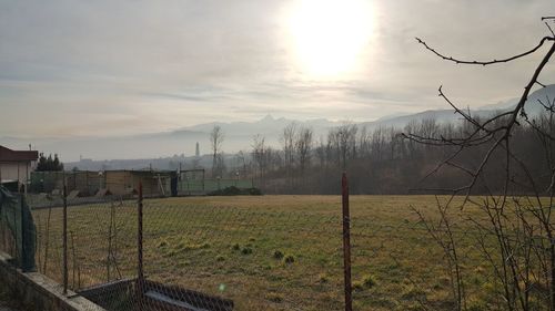 Scenic view of field against cloudy sky