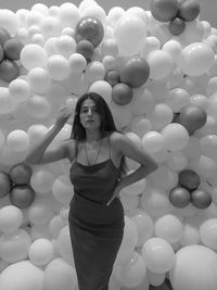 Portrait of woman standing at balloons