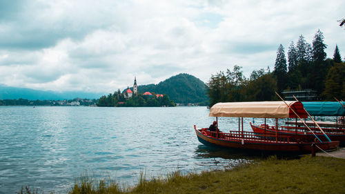 Boats moored on lake against sky