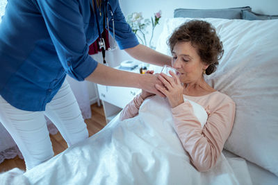 High angle view of friends lying on bed