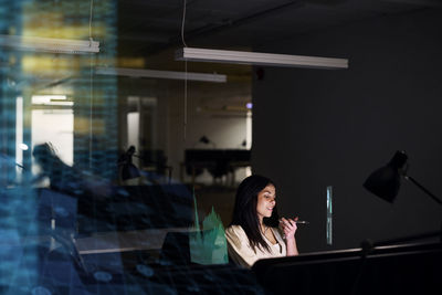 Young businesswoman working in office at night