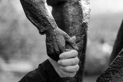 Cropped hand holding statue