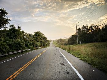 Road amidst trees against sky