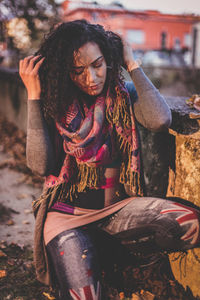 Close-up of young woman kneeling on footpath