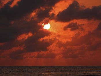 Scenic view of sea against dramatic sky during sunset