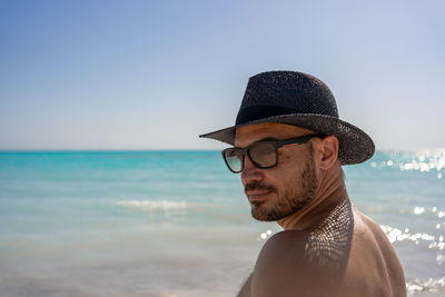 Man in summer hat and sunglasses on sea beach