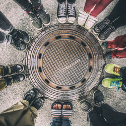 High angle view of people standing near manhole