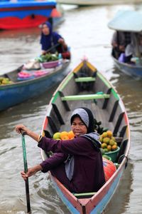 Woman selling food on boat in lake