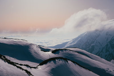 Scenic view of snowcapped mountains against sky during sunset