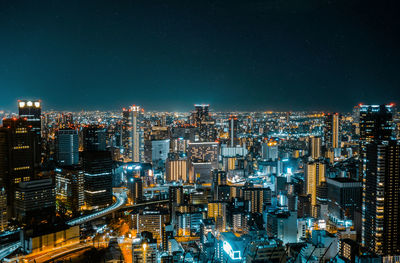 Illuminated cityscape against sky at night in osaka