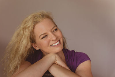 Portrait of smiling young woman against white background