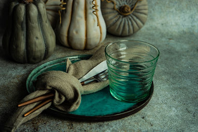 Autumnal table setting with leaves and pumpkin on wooden table