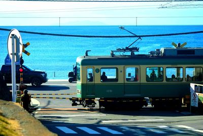 Railroad tracks by sea against sky