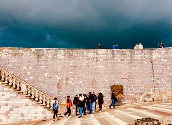 Group of people on staircase against the sky