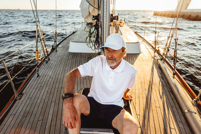 Young man sitting on boat in sea