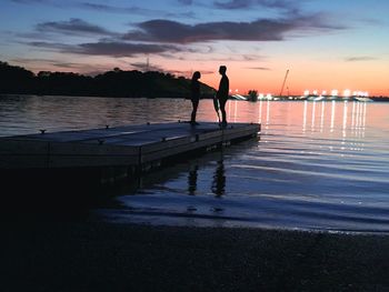 Silhouette of people on beach at sunset