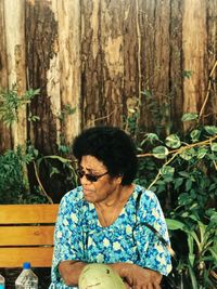 Mature woman sitting by plants 