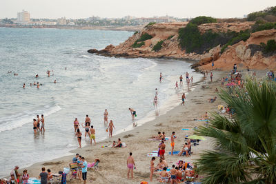 High angle view of people at beach against sky during sunset