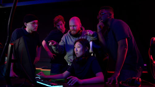 People playing video game in darkroom