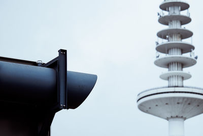 Low angle view of coin-operated binoculars by air traffic control tower against sky