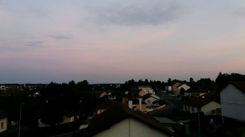 Houses in town against sky at sunset